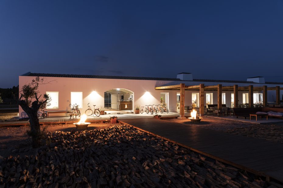 the exterior of craveiral farmhouse in portugal at night with lights shining from inside the property