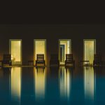 4 rectangular windows shining a bright reflection of the light onto the pool area at craveiral farmhouse a unique wedding venue in portugal