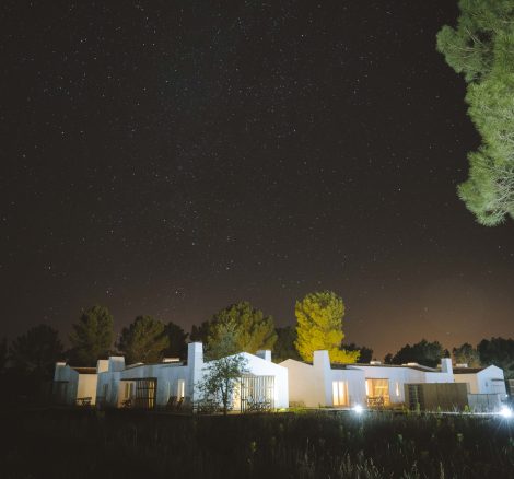 a beautiful shot of the starry night sky above white farmhouse structure wedding venue inn portugal called craveiral farmhouse