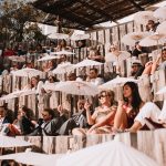 wedding guests sat with parasols at ibiza wedding venue Hacienda Na Xamena