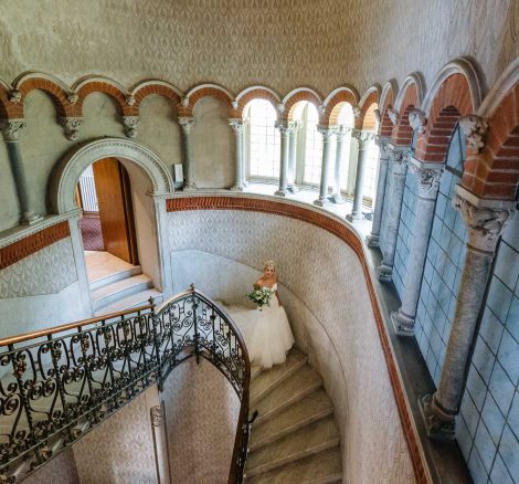 Bride walking down the elegant spiral staircase at wedding venue Villa Cipressi in Italy on Lake Como