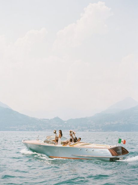 bride and her bridesmaids on a traditional wooden Italian boat from villa cipressi in Italy
