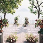 Wedding Ceremony with clear acrylic chairs and pink flower arrangements at Villa Cipressi on Lake Como