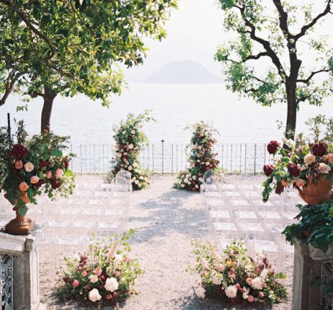 Wedding Ceremony with clear acrylic chairs and pink flower arrangements at Villa Cipressi on Lake Como