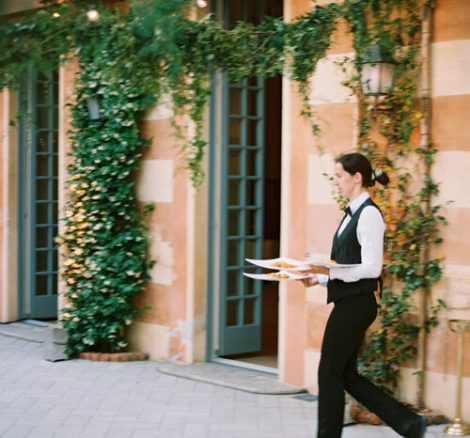 Waiter serving wedding meal outside Italian wedding venue Villa Cipressi