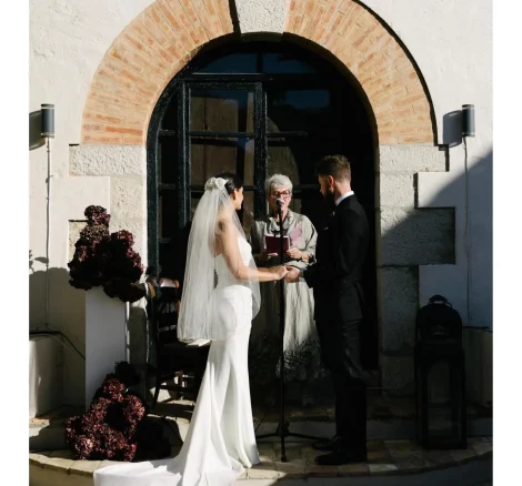 Image of couple getting married at end of aisle at wedding venue Masia Victoria