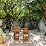 wooden chairs and old tables in courtyard at wedding venue in puglia Masseria Don Luigi