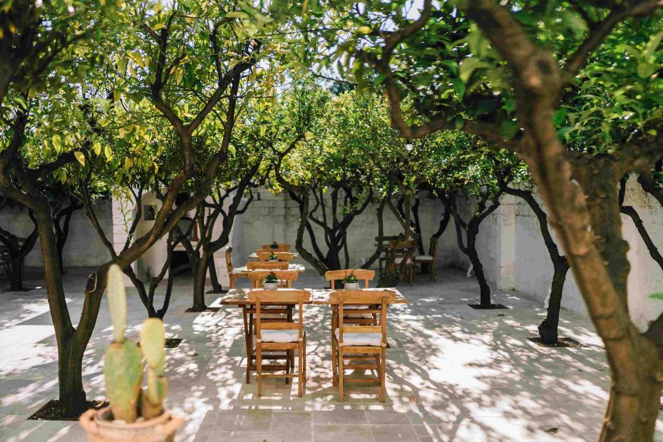 wooden chairs and old tables in courtyard at wedding venue in puglia Masseria Don Luigi