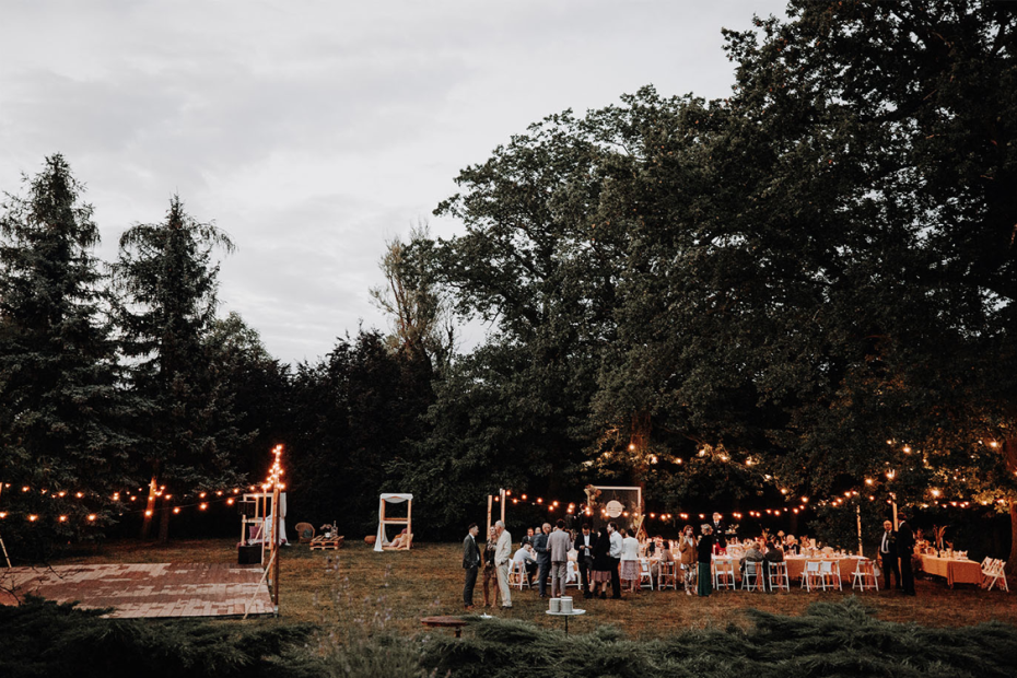 the wedding reception outdoors with fairy lights of polish wedding venue the palace osowa sien