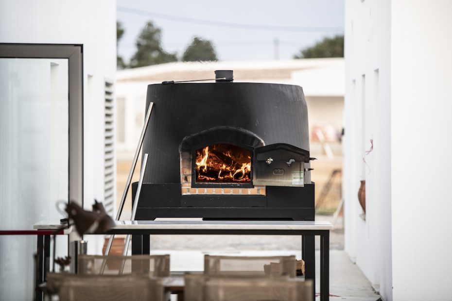 lit wood burning stove for pizza at wedding venue craveiral farmhouse in alentejo inn portugal