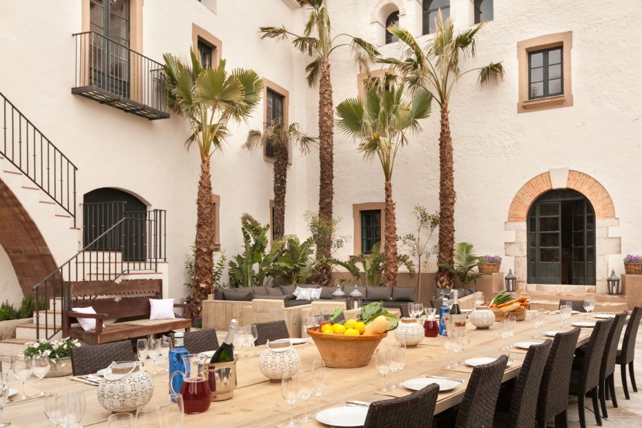 outside area by the pool with 4 palm trees at spanish wedding venue Masia Victoria
