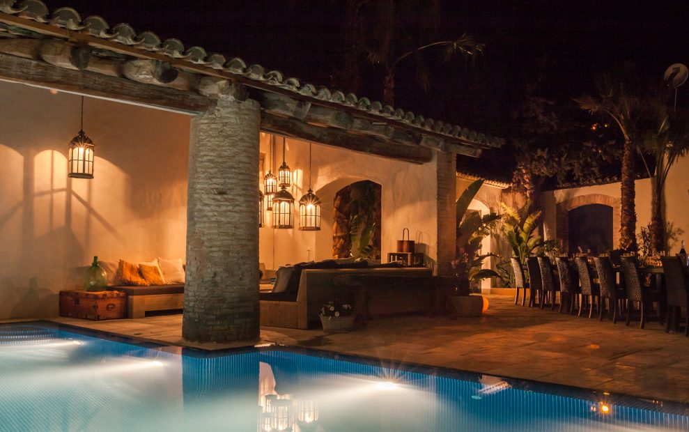 the pool lit up at night by the courtyards outside spanish wedding venue Masia Victoria