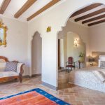 spanish style bedroom with stone floor and white walls with a lounge area at villa Catalina in spain