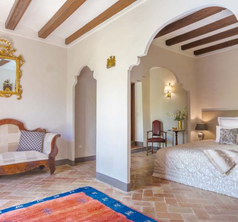 spanish style bedroom with stone floor and white walls with a lounge area at villa Catalina in spain