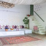 Open air lounge area with seating and stair up into villa