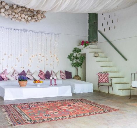 Open air lounge area with seating and stair up into villa