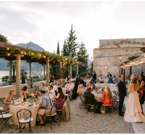 wedding guests seated for the wedding meal outside looking out over lake como at Italian wedding venue Villa Cipressi