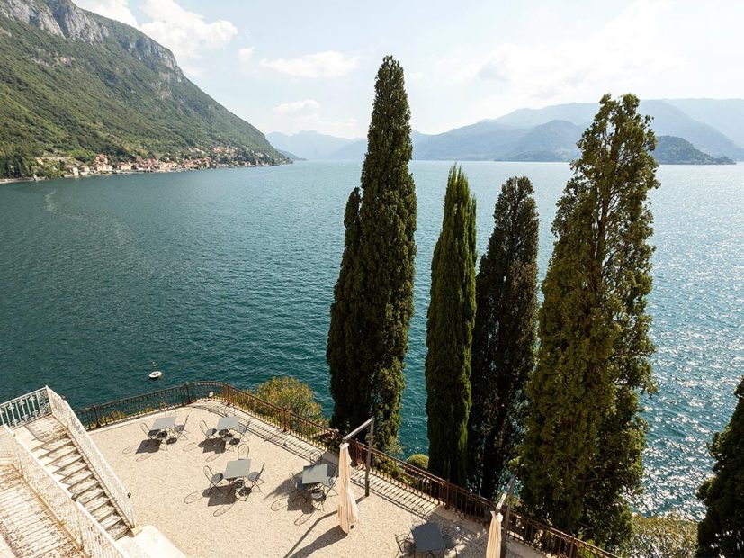 view over lake como with 3 tall cypress trees at villa cipressi