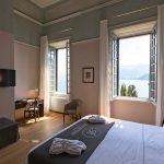Double bedroom with two large windows that look over Lake Como at Villa Cipressi a unique destination wedding venue