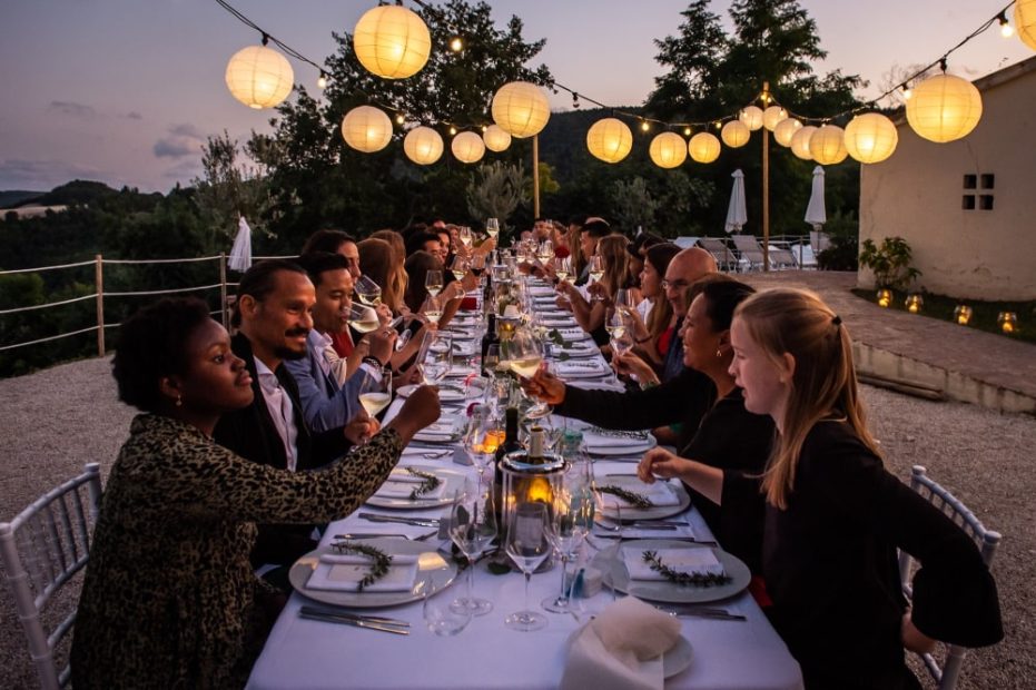wedding guests cheers-ing during wedding breakfast at sundown