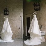 white wedding dress hung against stone wall backdrop at Italian wedding venue