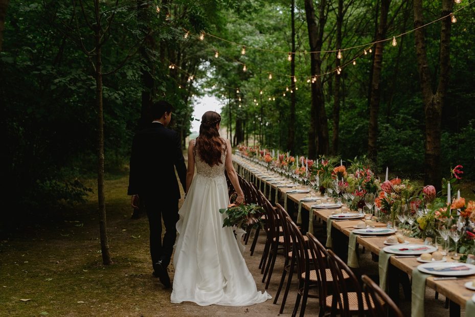 bride walking through forested area along long rectangular table at Italian wedding venue convento dell'Annunciata