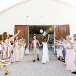 bride and groom celebrating as they exit the indoor wedding ceremony at Italian estate surrounded by guests throwing confetti