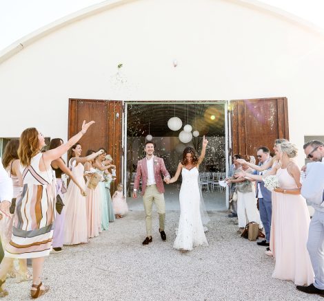 bride and groom celebrating as they exit the indoor wedding ceremony at Italian estate surrounded by guests throwing confetti
