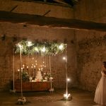 cake suspended on a wooden swing surrounded by fairy lights at Italian wedding venue convento dell'Annunciata