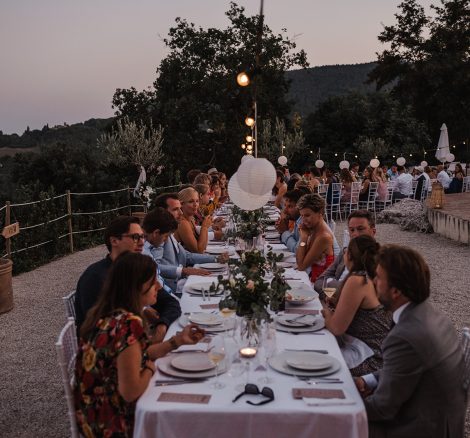 long rectangular tables with guests seated for the wedding breakfast at dusk