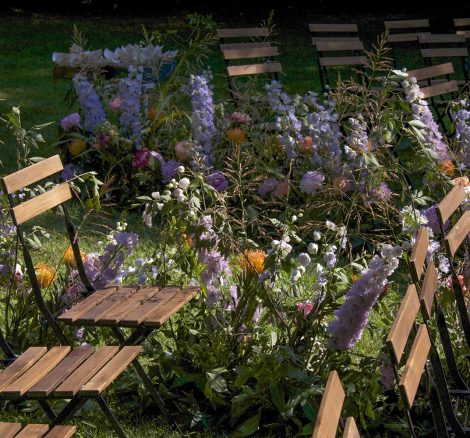 wooden ceremony chairs and purple flowers