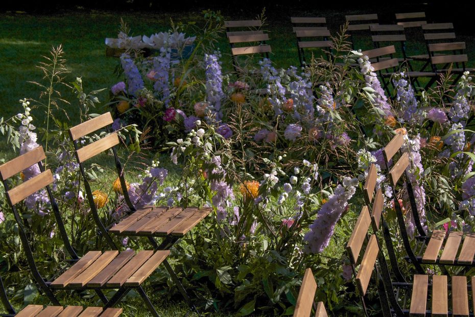 wooden ceremony chairs and purple flowers