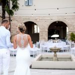 Bride and Groom first look at wedding breakfast tables set up in the courtyard at Italian country house wedding venue Le Stonghe