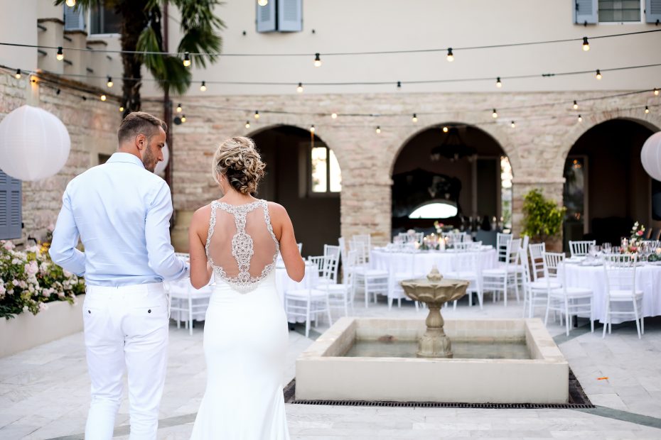 Bride and Groom first look at wedding breakfast tables set up in the courtyard at Italian country house wedding venue Le Stonghe