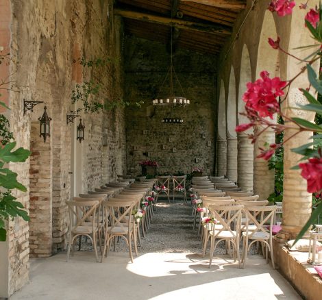wooden seats set up for wedding ceremony in unique stone structure