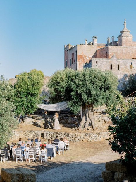 outside wedding ceremony on the farmland between olive trees at Italian wedding venue masseria spina