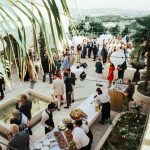 wedding guests mingling during reception drinks outside on the grounds of Italian estate le stonghe