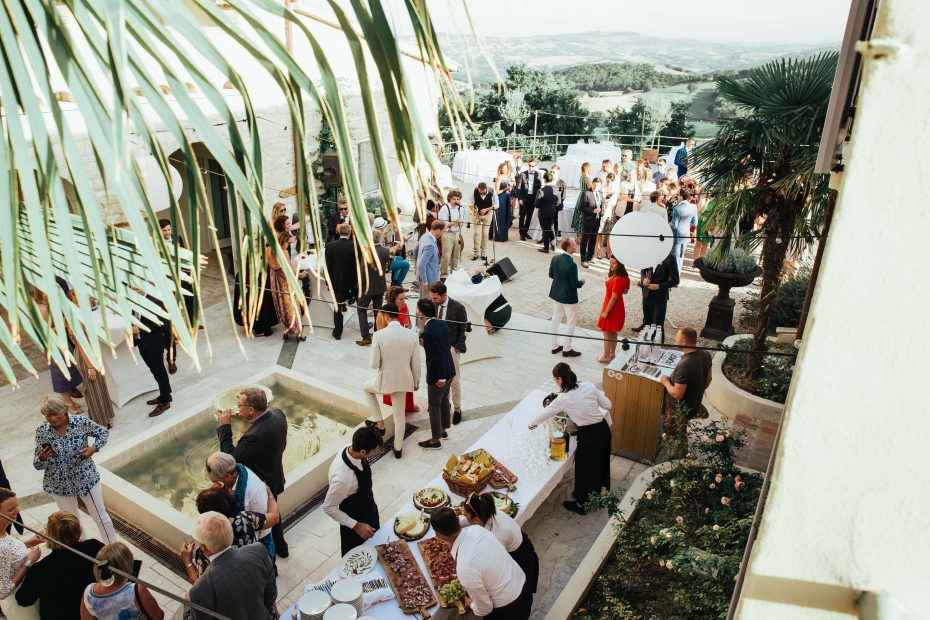 wedding guests mingling during reception drinks outside on the grounds of Italian estate le stonghe