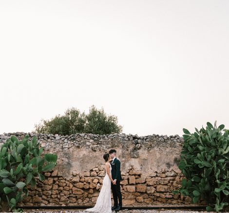 bride and groom stood together between Puglia cacti at Italian wedding venue masseria spina