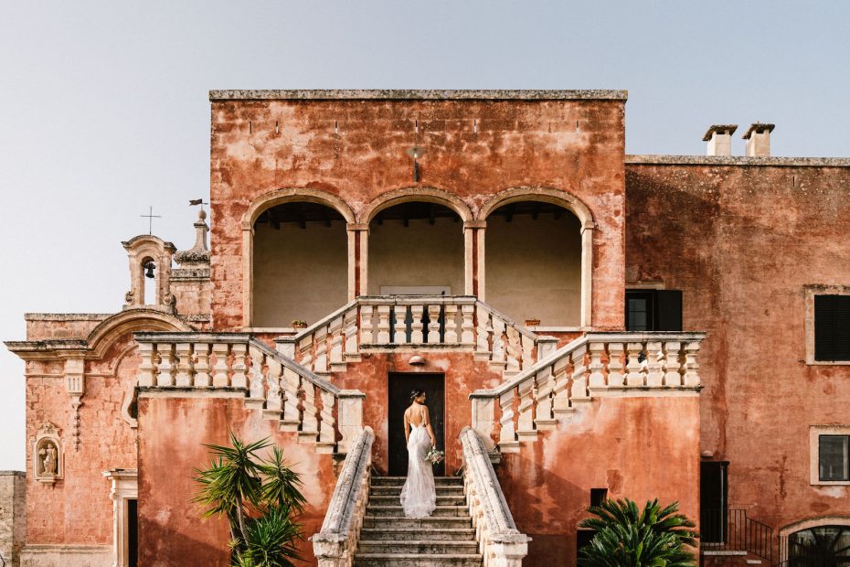bride on the outer steps at wedding venue in Italy masseria spina