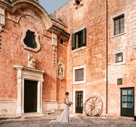 bride stood with her bouquet on the grounds at Italian wedding venue masseria spina