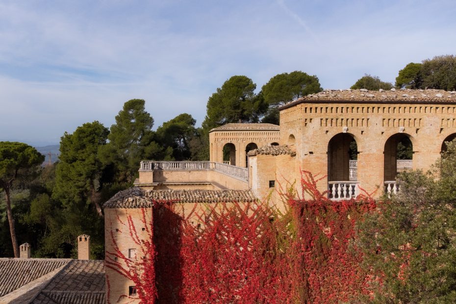 Red leafy vine cascading over the stone exterior at Italian wedding venue Villa Imperiale Pesaro