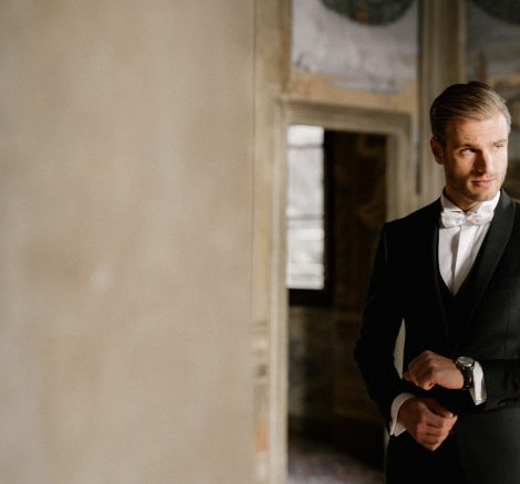 groom getting dressed into a black tux at Italian wedding venue Villa Imperiale