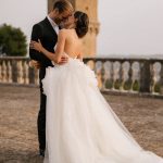 Bride and groom embracing on the rooftop of historic Italian wedding venue
