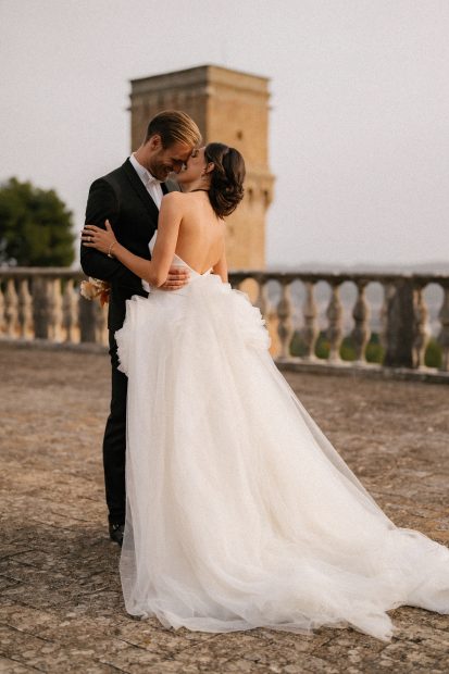Bride and groom embracing on the rooftop of historic Italian wedding venue