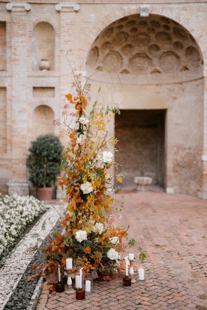 autumnal floral arrangement for an Italian wedding ceremony with white pillar candles