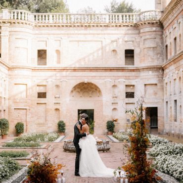 bride and groom stood together in the courtyard surrounded by stone walled garden at Italian wedding venue Villa Imperiale Pesaro