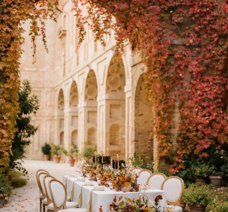 wedding table set up with autumnal florals against the stone arched cloisters