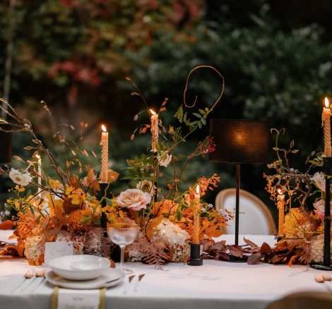 wedding table with autumnal coloured florals and tall candles at Italian wedding venue