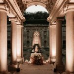 lights illuminating 4 stone pillars and cake display at Italian wedding venue Villa Imperiale
